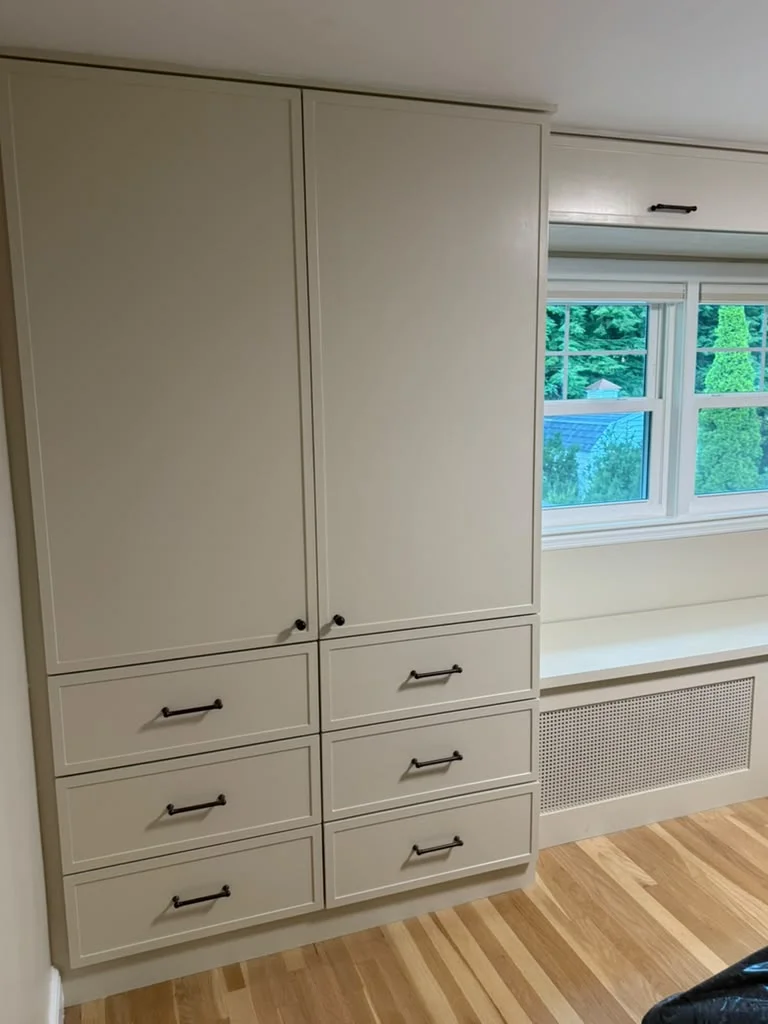 Custom Built-in Drawers and Window Seat Custom built-in cabinets and drawers with black hardware, next to a window seat. by ALP Home Services in Cambridge, MA