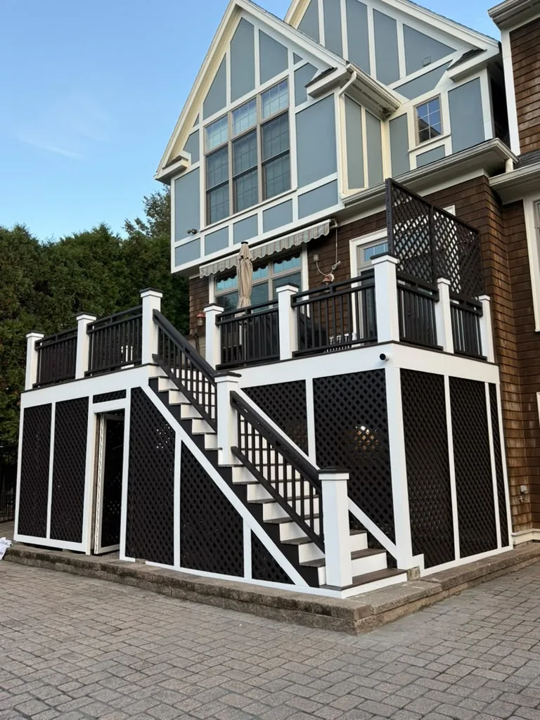 After deck painting in Newton, MA: elevated deck with crisp white trim and dark brown railings and lattice by ALP Home Services