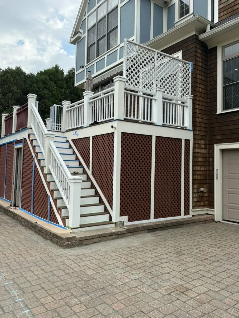 Deck painting prep: new railings and lattice privacy screen primed white before the color coats