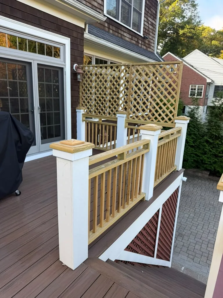 Before: new unpainted wood railings, post caps and lattice privacy screen on a deck in Newton, MA