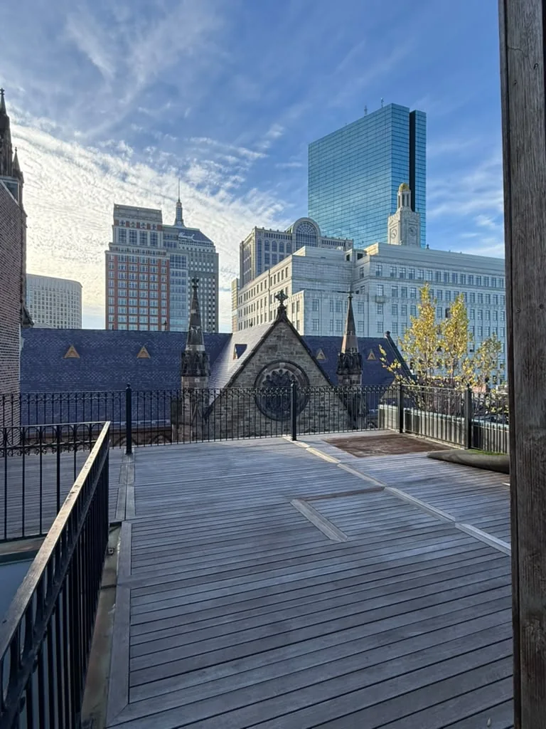 Before rooftop deck sealing in Back Bay, Boston: weathered gray mahogany decking with the John Hancock Tower in the background