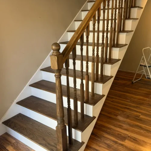 Beautifully finished hardwood stairs with white risers and dark wood flooring in a home. by ALP Home Services in Boston, MA