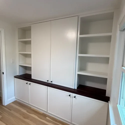 Custom white built-in cabinets with dark wood countertops and light hardwood flooring. by ALP Home Services in Medford, MA